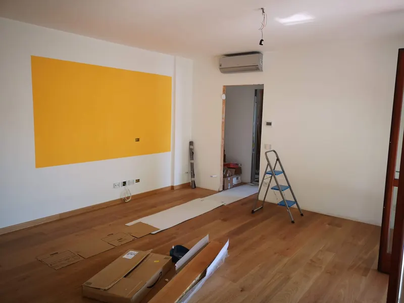 Sala vazia no fim de uma remodelação, com escadote e materiais
